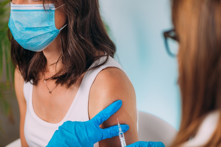 kvinna med skyddsmask vaccineras mot covid 19 syntetiska antikroppar