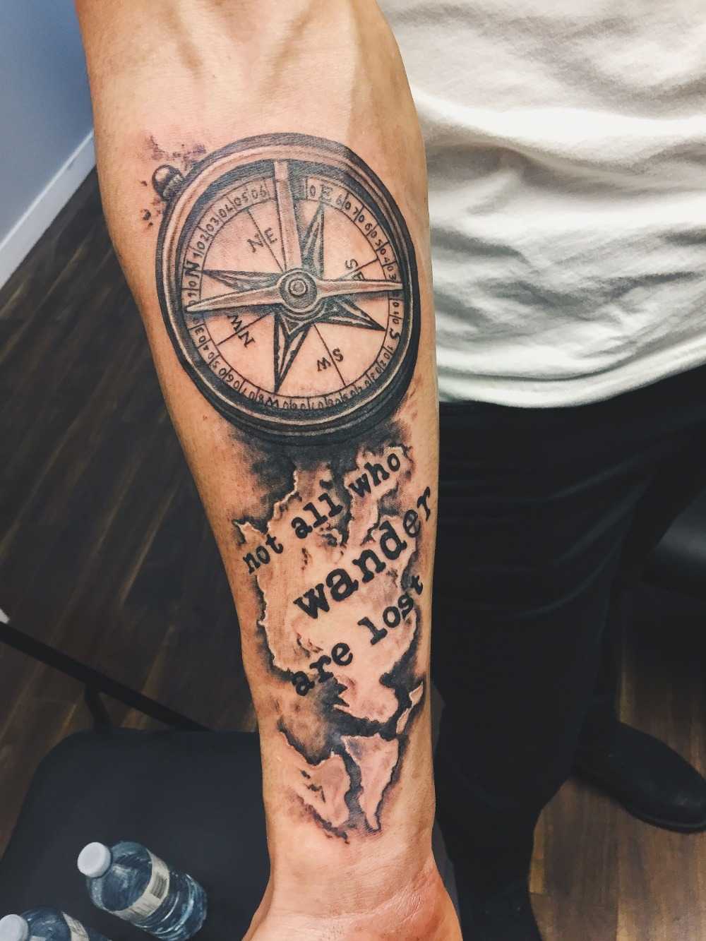 resetatueringar med kompass och karta med bokstäver citat tatuering arm man
