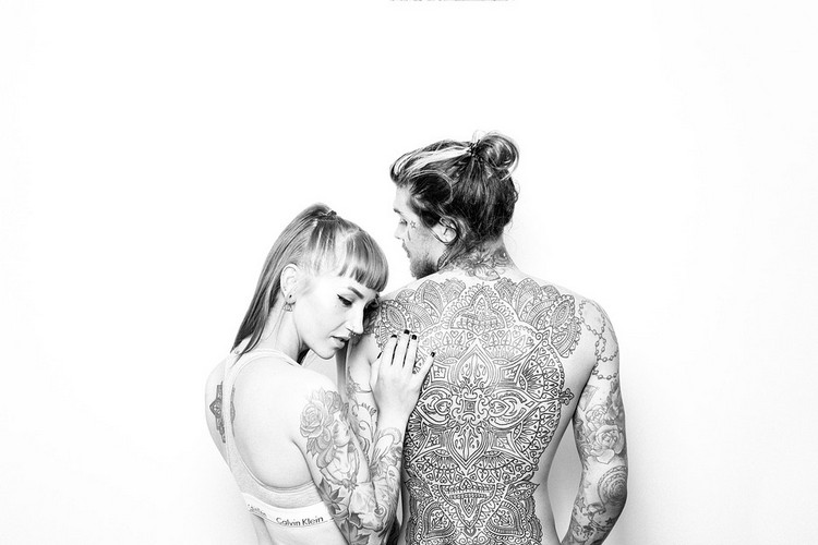 kvinna och man med tatueringar poserar