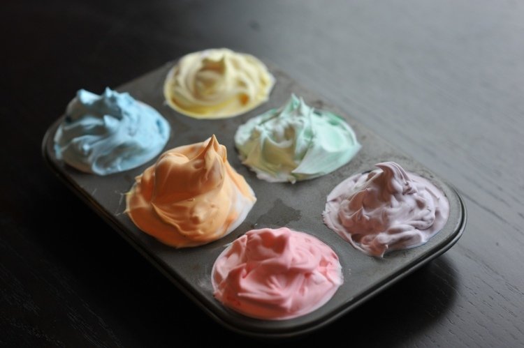 Blanda färgerna i en muffinsform med rakskum
