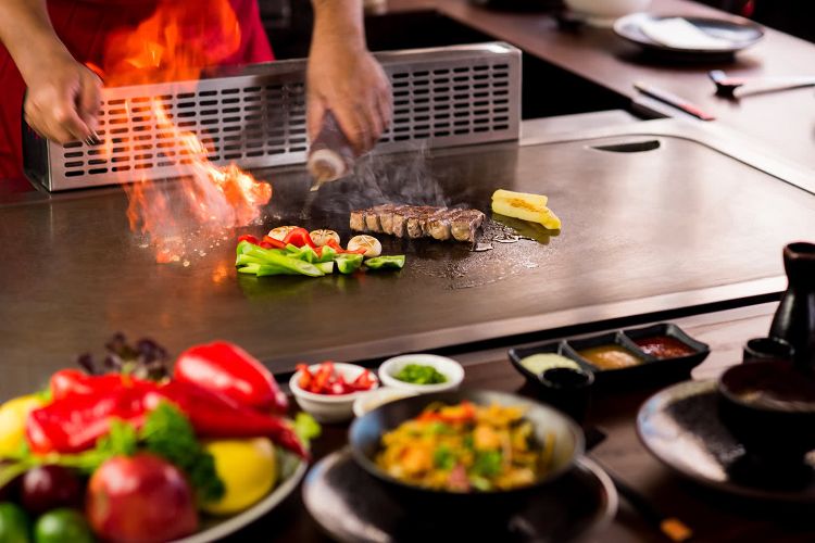 teppanyaki tallrik grillare japansk matlagning exotiska rätter skaldjur förbereda eld släcka paprika grönsaker fläsk västerländsk smak