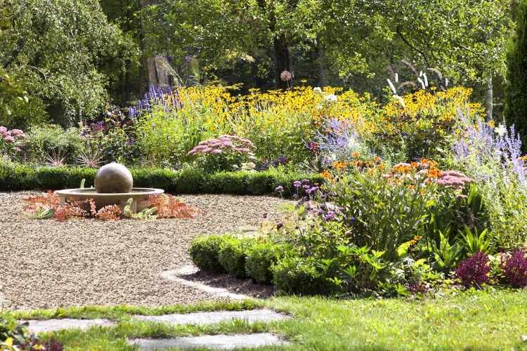 vacker solig trädgård med utomhus fontäner och färgglada växter
