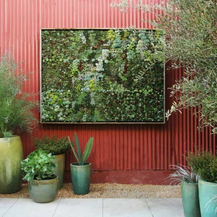Grön terrassvägg med en vertikal trädgård i ramen för moderna terrasser