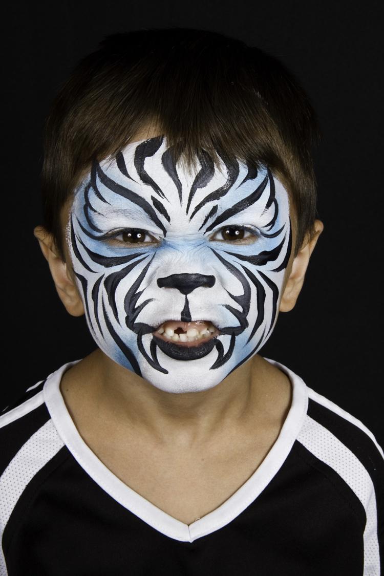 vit tiger som applicerar smink till barnpojke