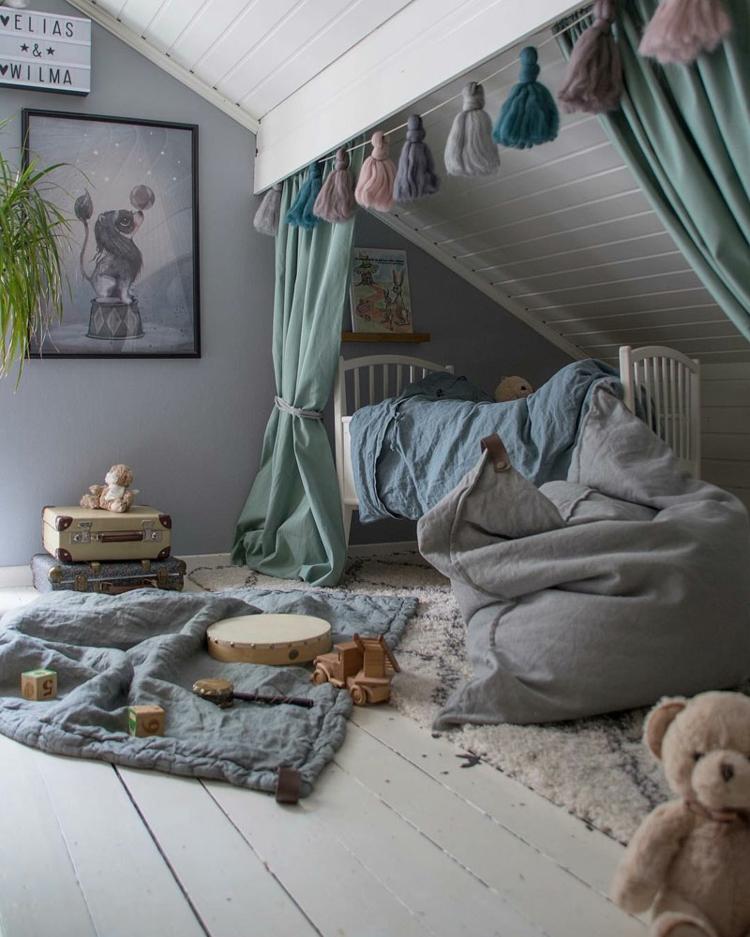 Mysigt hörn under sluttningen med gardiner och tofsar som dekoration