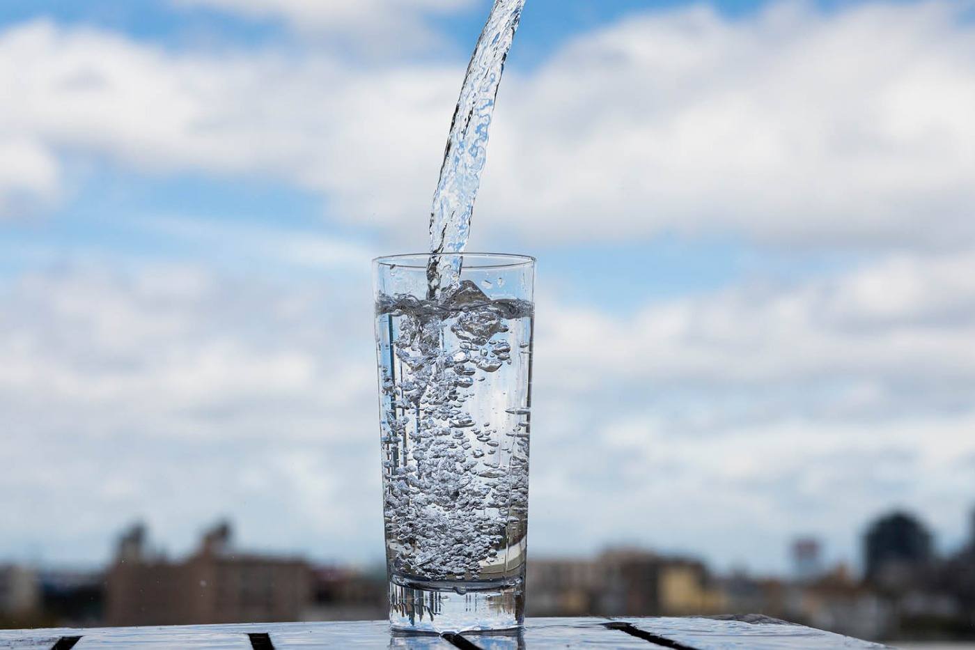 Häll vatten i ett glas under sommaren och hydrera kroppen och ät vätska