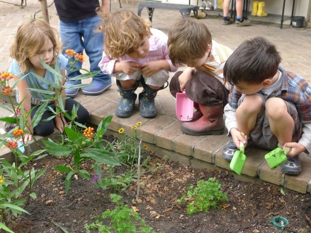 Trädgårdsunderhåll barn arbetar jordblommor fyra pojkar
