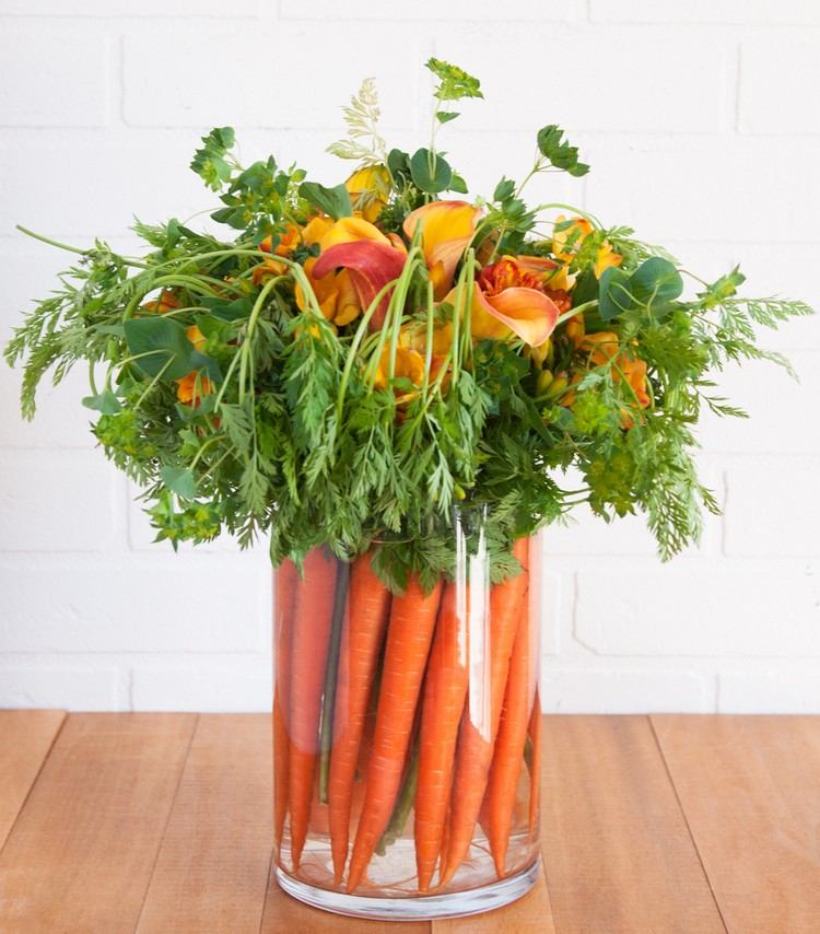 bordsdekoration med morötter och blommor vas