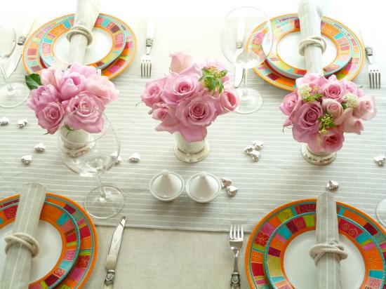 bordsdekoration buketter av rosor vita bordsduk färgglada tallrikar