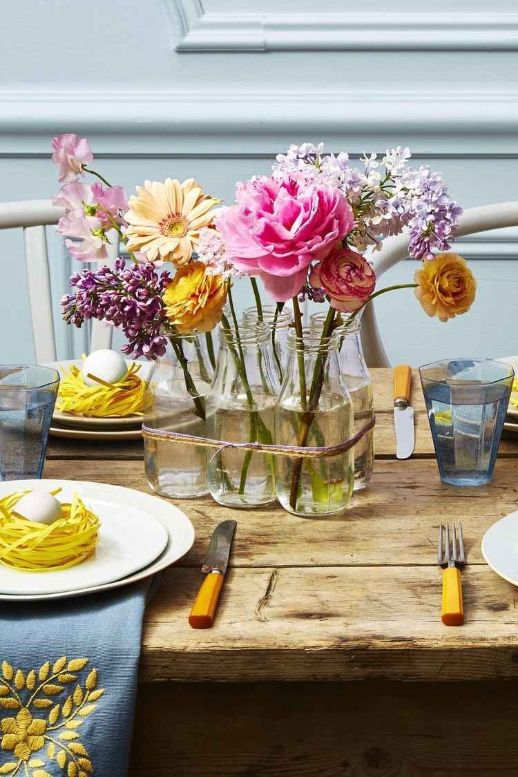 Bordsdekorationer i pastellfärger med färska blommor i frostat glas