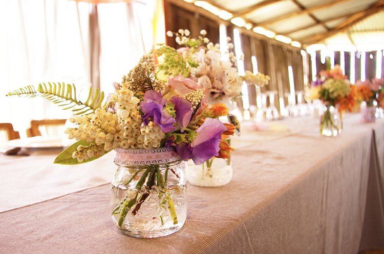bordsdekoration med blommor mason jar vas spetsband