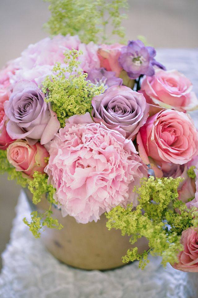 Blomsterarrangemang av rosa lila rosor på bordet ser fräscha ut
