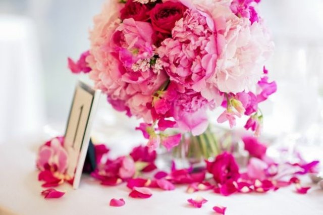 Ett bord i en kristallvas arrangerar romantiska, lekfulla blomsterarrangemang