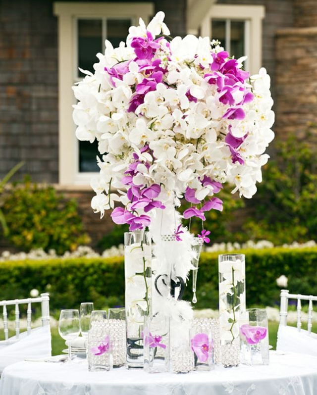 Bordet ordnar lila vit färg orkidéer hög bukett