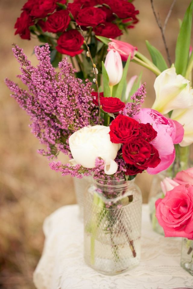 vita rosor röda nejlikor rosa delphinium på bordet