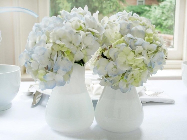 Bordsdekoration med hortensior-bröllop-vas-vit-ljus-bblue-gulaktig-bordsduk-fönster