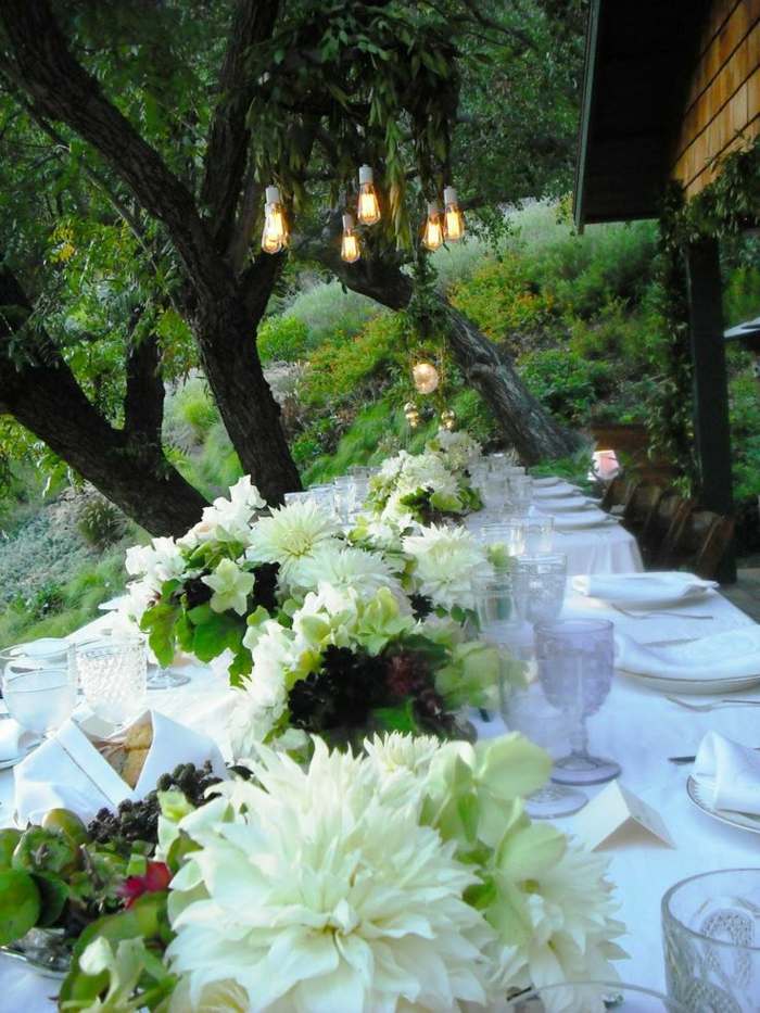 trädgård bröllop bord dekorationer vita blommor romantiska lyktor