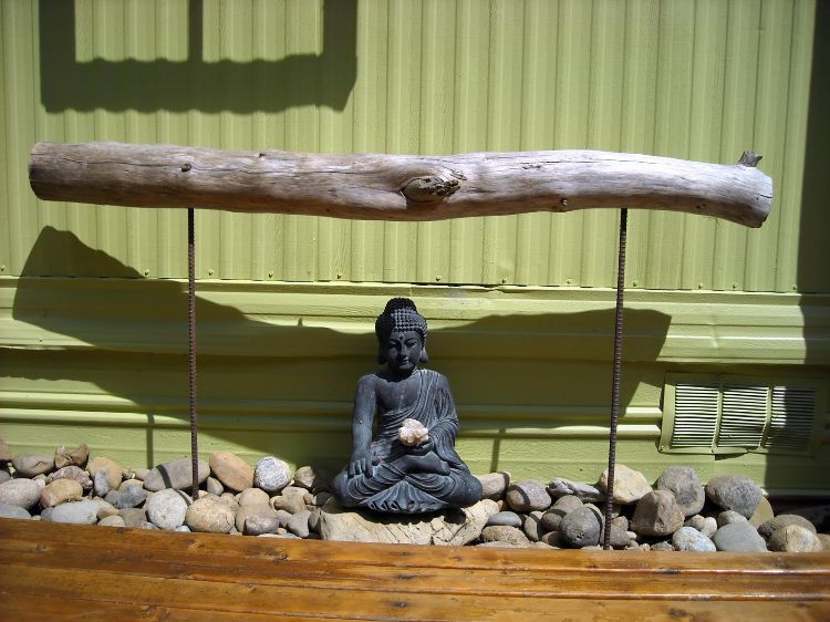 trädgård konst drivved borrning stålstavar buddha figur sten plåt vägg solljus