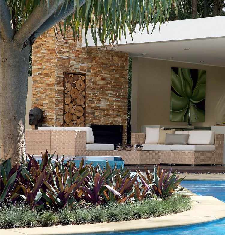 trädgård-lounge-set-design-idéer-beige-korg-vita-kuddar-öppen spis-vägg-natursten