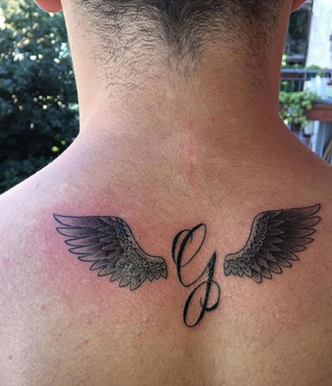 Cursive G τατουάζ με φτερά στην πλάτη