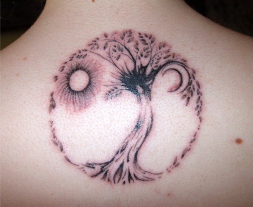 Aurinko ja kuu puun tatuoinnilla