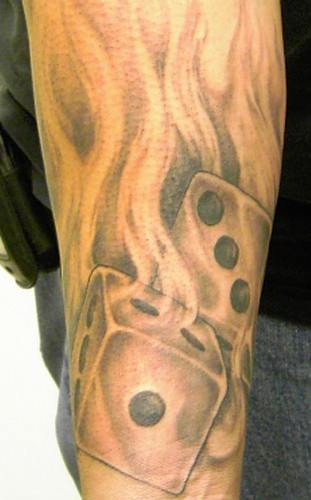 Το κρανίο και τα ζάρια φωτιά τατουάζ στο αντιβράχιο