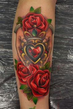 Irlantilainen Claddagh -tatuointi punaisilla ruusuilla