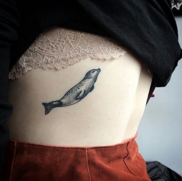 tatueringar kvinnor revben diskret svart minimalistisk djursäl