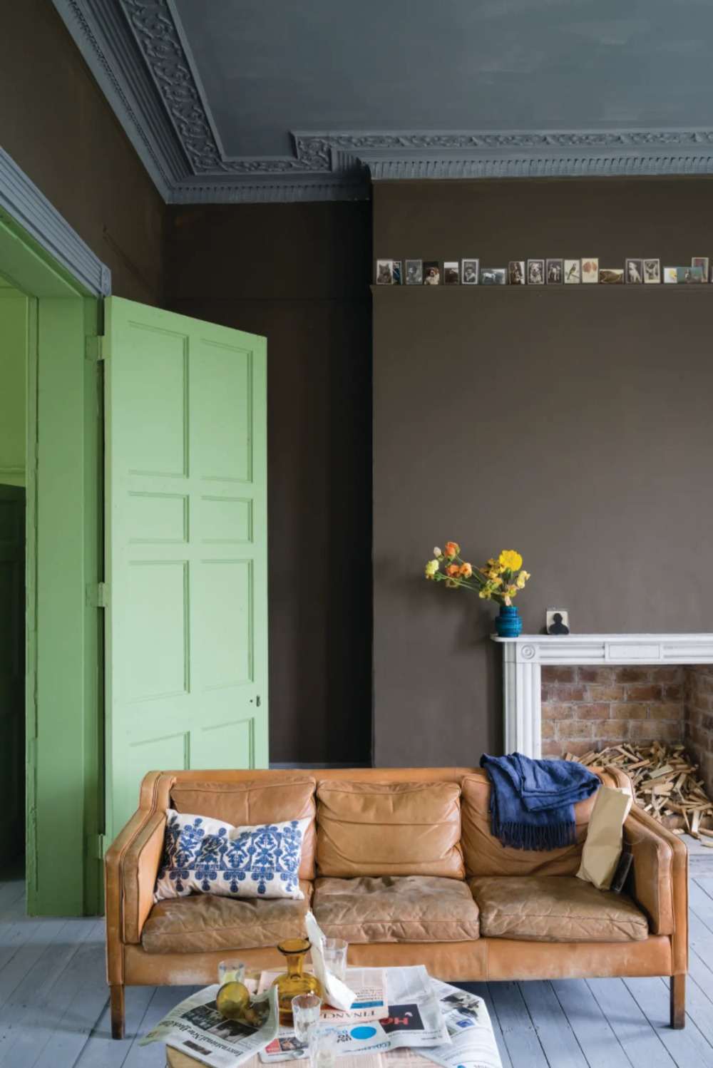 rustika innerdörrar målar äggskal mattgrönt för att matcha lädersoffan i vardagsrummet