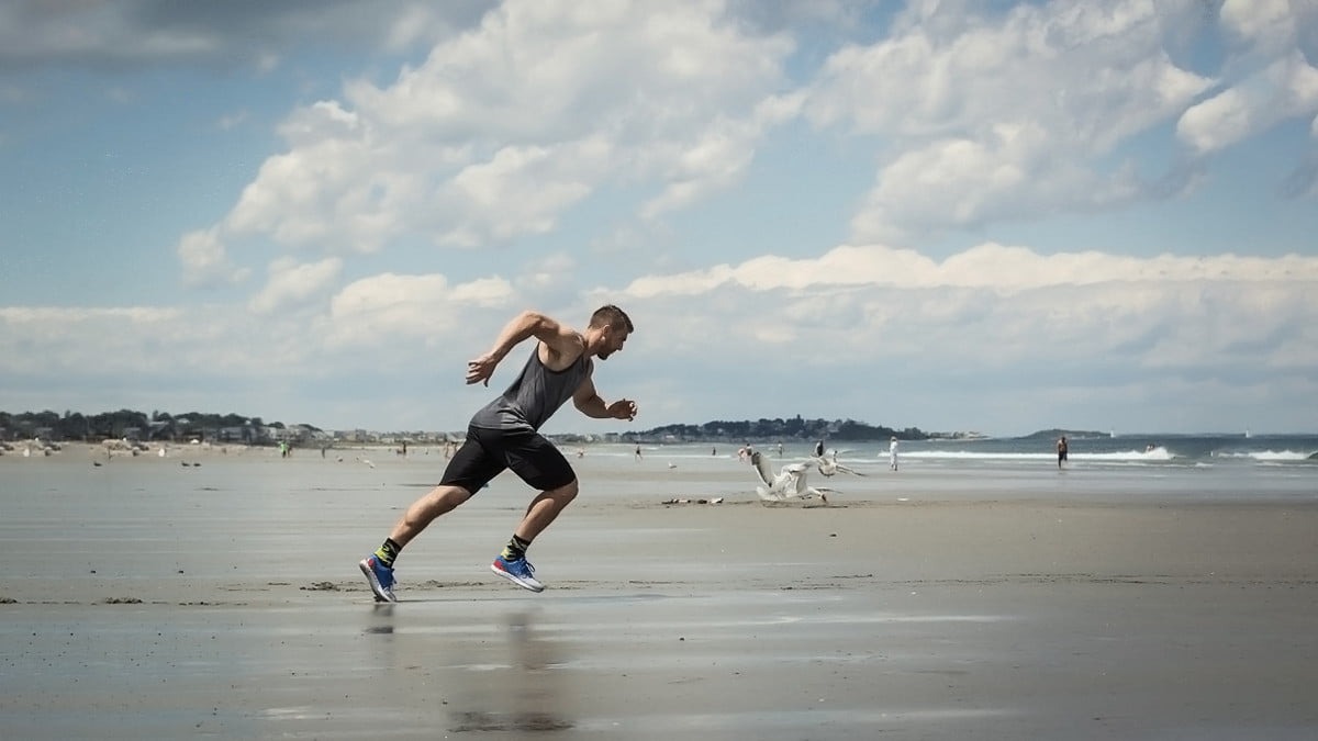 Idrottare styrketräning på stranden träning med sprint