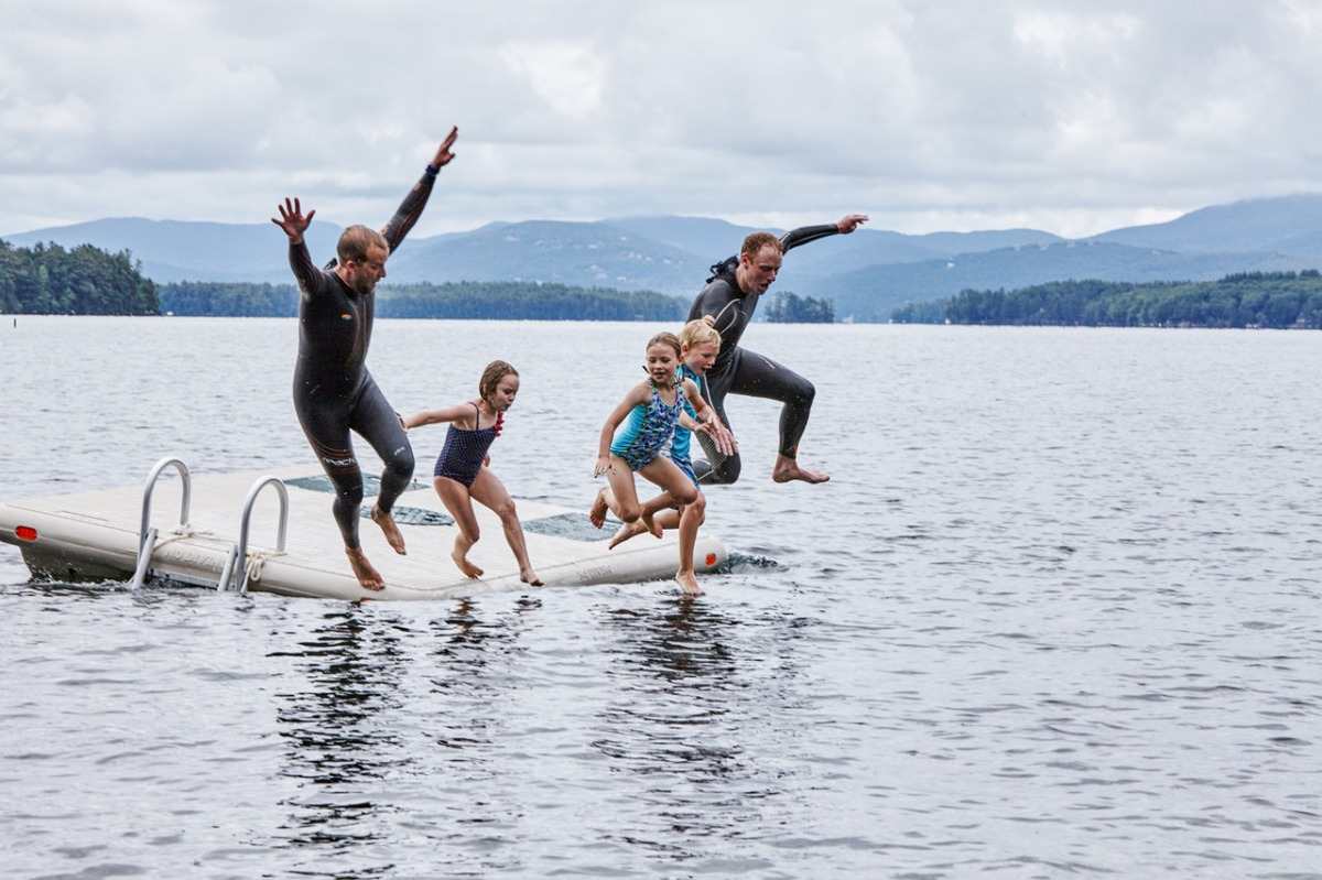 Lek med familjen och barn som hoppade i sjön från plattformen