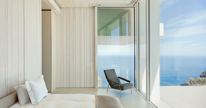 sovrum design hus balkong havsutsikt säng fåtölj