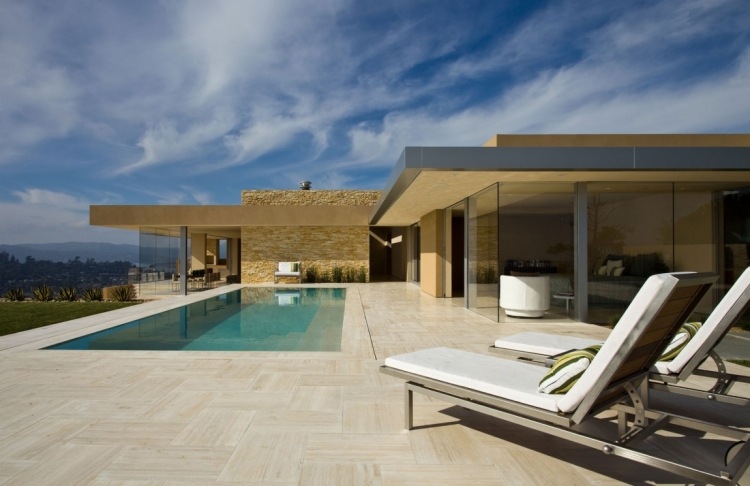 Travertinplattor utomhus-infinity-pool-solstolar-glasfronter-fint väder-modern-arkitektur
