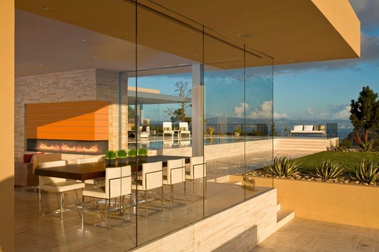 Travertinplattor -hus-modern-arkitektur-glasfronter-matbord-stolar-dekorativ-öppen-utsikt