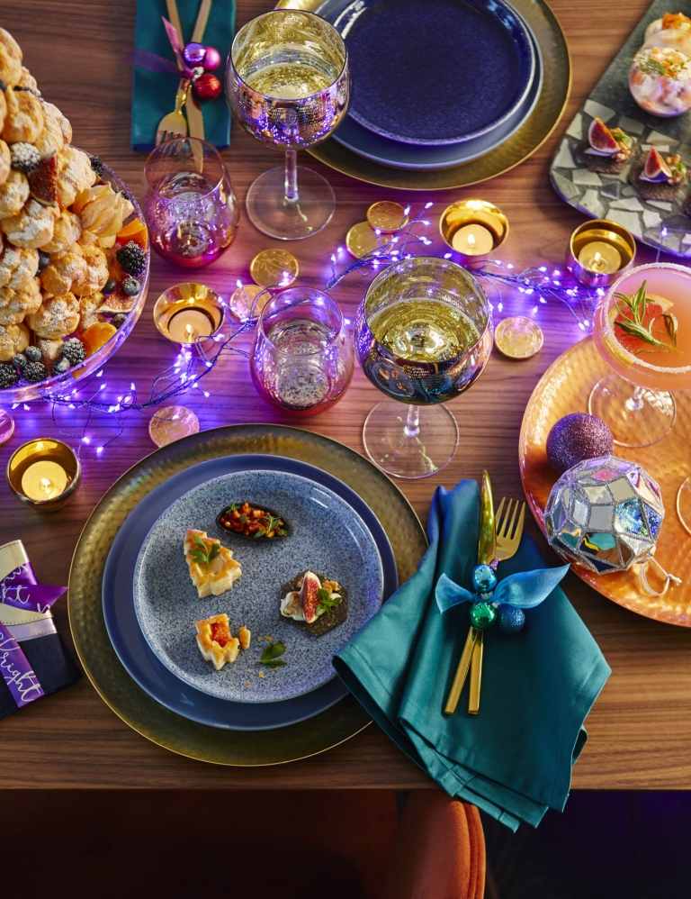 Färgtrender jul 2019 lila LED -fe -lampor och mörkblå servetter och bestick i guld
