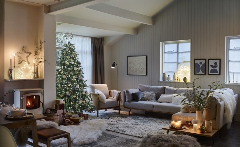 Vardagsrum i en skandinavisk look med en julgran helt dekorerad i vitt