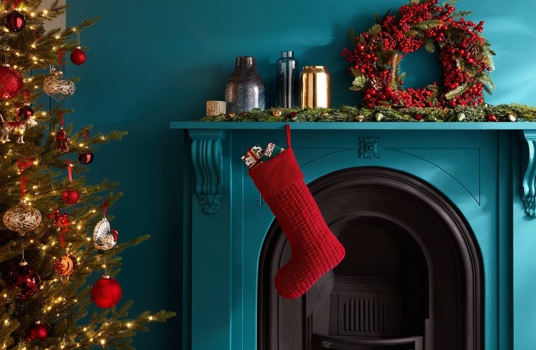 Trendfärger jul 2019 dörrkrans av grangrenar och bär och röda julkängor