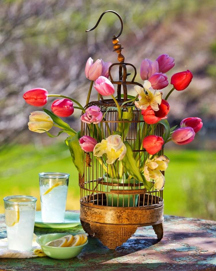 Ordna blomsterarrangemanget med tulpaner i buren dekorativt