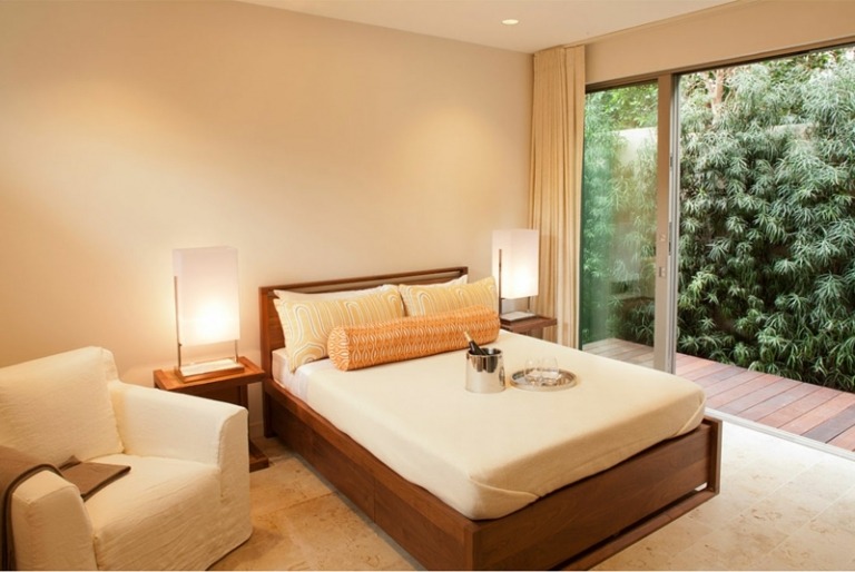 husdesign sovrum beige brun fåtölj belysning sängskåp