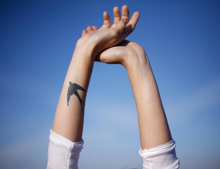 underarm tatuering kvinna inuti svälja motiv