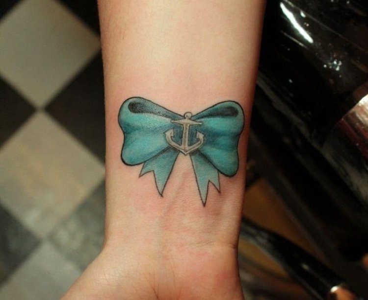 underarm-tatuering-kvinna-handled-inuti-blå-rosett-ankarmotiv