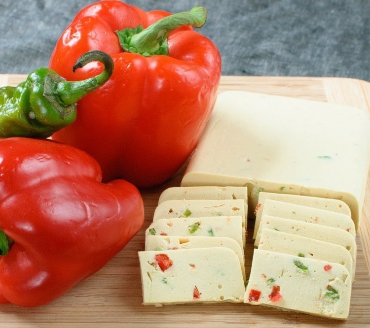 vegansk ost skivad ost-paprika-paprika-röd-grön skärbräda