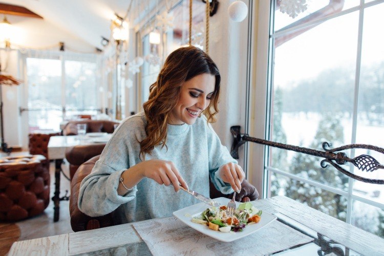 kvinna äter vegetarisk sallad i restaurangen