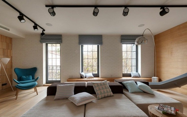 vardagsrum-golv till tak-fönster-soffa-trä-väggdekoration-fåtölj-pall-belysning-båglampa