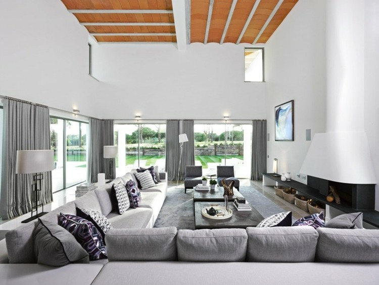 interiör vit villa vardagsrum grå möbler gardiner eldstad soffa