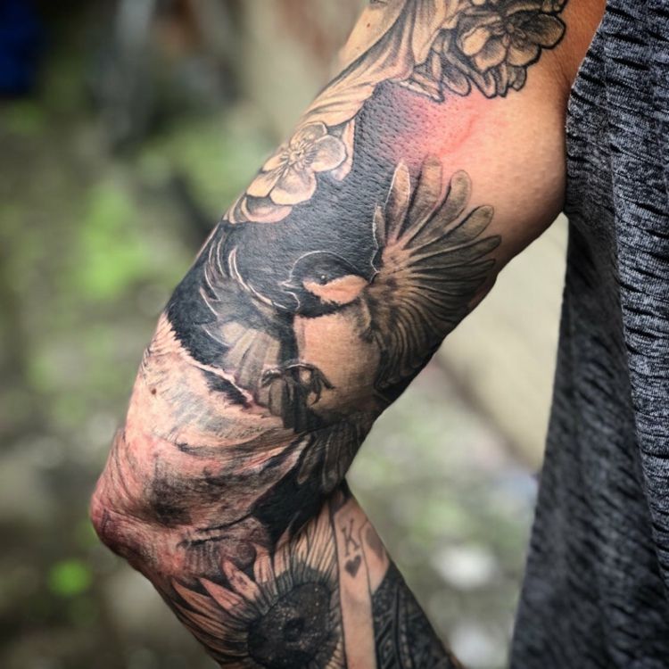 Män tatuering med blå majs och blommor för armen