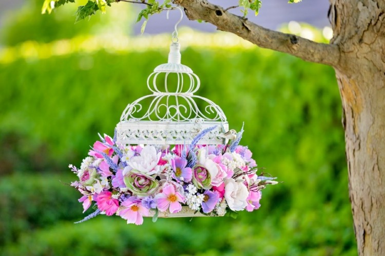 Enkel DIY -idé med blommor i romantiska färger i en liten bur