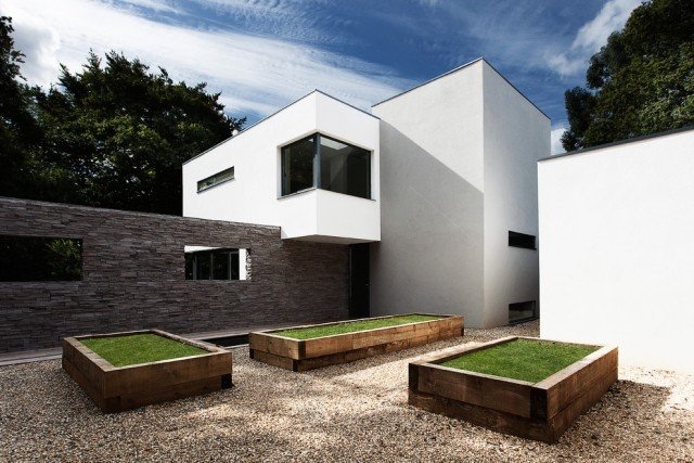 Modernt hus med platt tak-exteriör-golv-grus-vatten-bundet-rullat-grustak