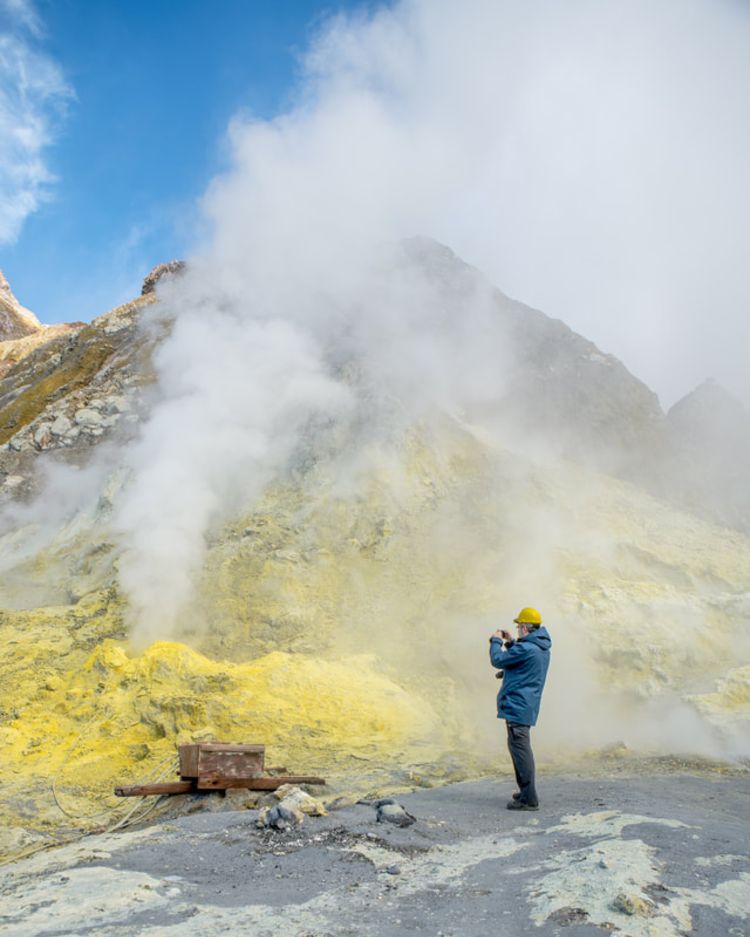 Turist promenader på kratern i en vulkan på White Island