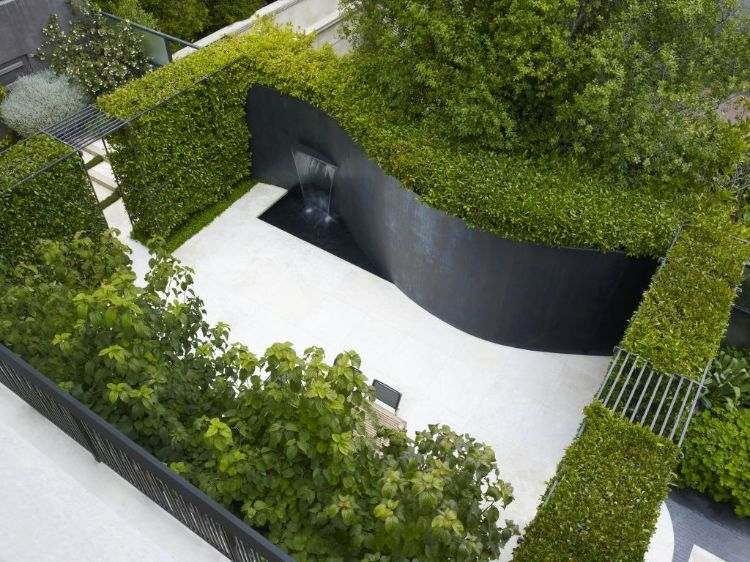 vägg fontän modern inuti utanför design stenmur vatten funktion växter häck trädgård